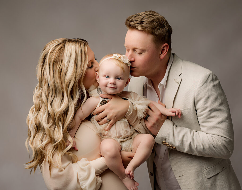 Austin family poses for family picture with 6 month old daughter while kissing her head 